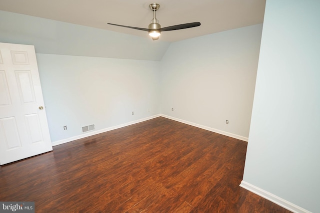 spare room featuring ceiling fan, dark wood-type flooring, and vaulted ceiling