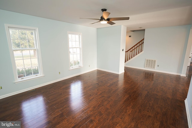 unfurnished room with plenty of natural light, ceiling fan, and dark wood-type flooring