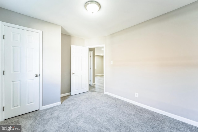 unfurnished bedroom featuring light carpet and a closet