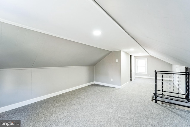 additional living space featuring carpet and vaulted ceiling