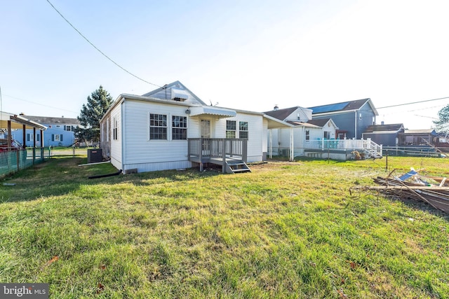 rear view of house featuring a lawn, central AC, and a deck