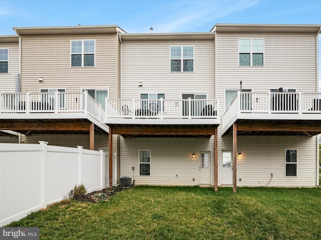 back of property with a lawn and central AC