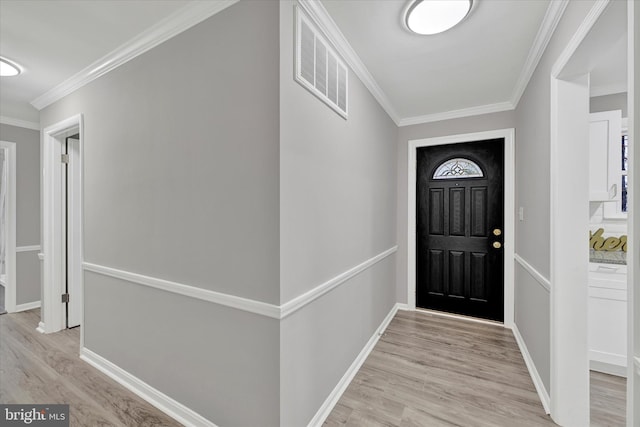 entrance foyer with ornamental molding and light hardwood / wood-style flooring