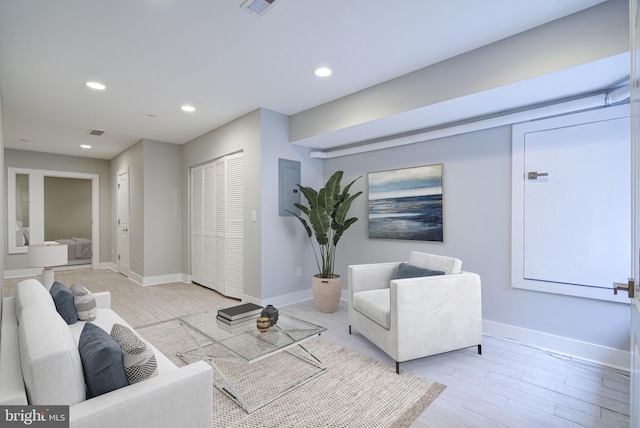 living room with electric panel and light hardwood / wood-style flooring