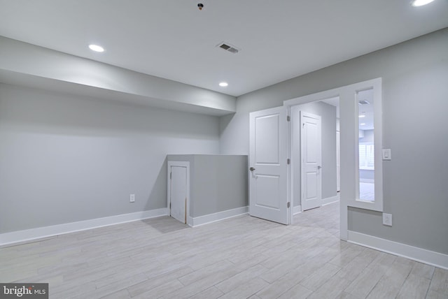 basement with light hardwood / wood-style floors