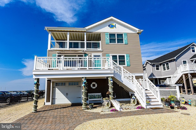 raised beach house featuring a porch and a garage