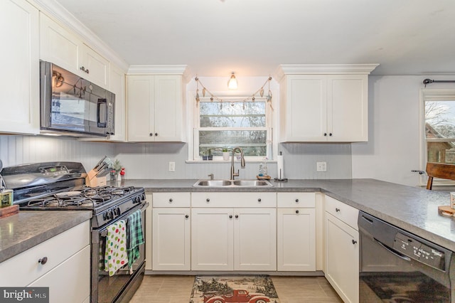 kitchen with black appliances, white cabinetry, and sink