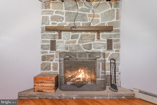 interior details with hardwood / wood-style floors, a fireplace, and a baseboard heating unit