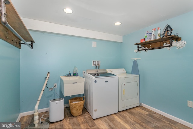 laundry area featuring sink, hardwood / wood-style floors, and independent washer and dryer