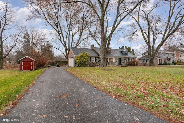 view of front of property featuring a front lawn and a storage unit