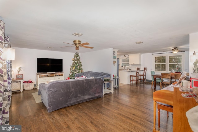 living room with dark hardwood / wood-style flooring and ceiling fan