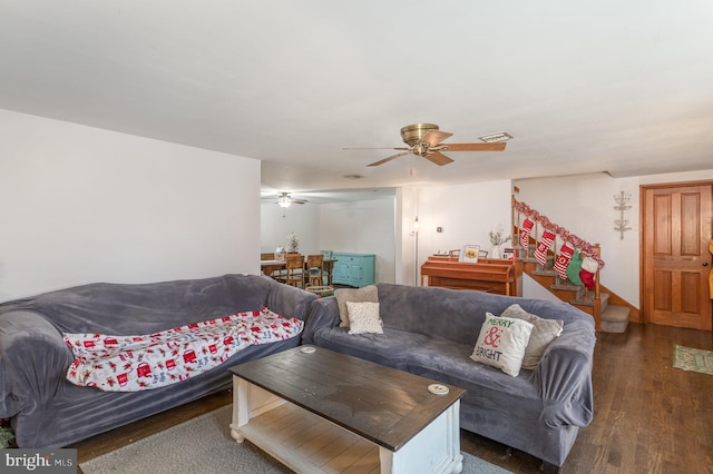 living room featuring ceiling fan and dark wood-type flooring