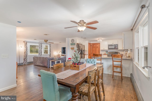 dining area with ceiling fan, dark hardwood / wood-style flooring, and a baseboard radiator