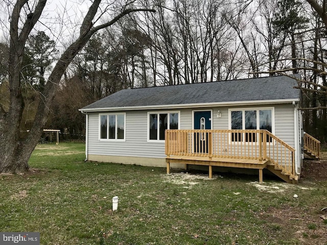 view of front of property with a wooden deck and a front lawn