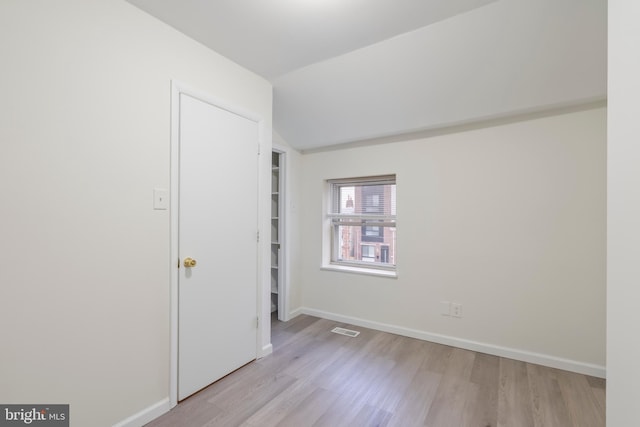 empty room featuring light hardwood / wood-style flooring and lofted ceiling