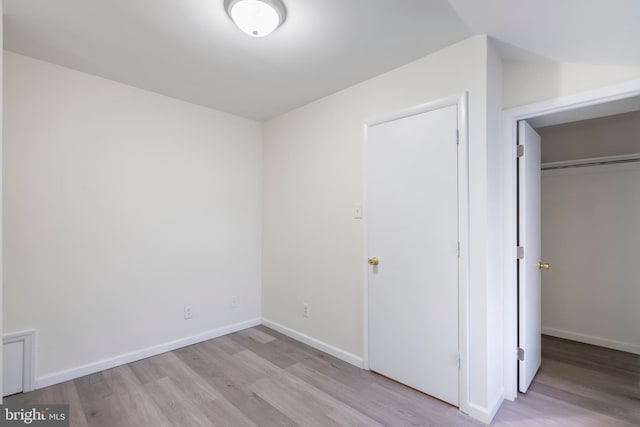 unfurnished bedroom with a closet and light hardwood / wood-style flooring