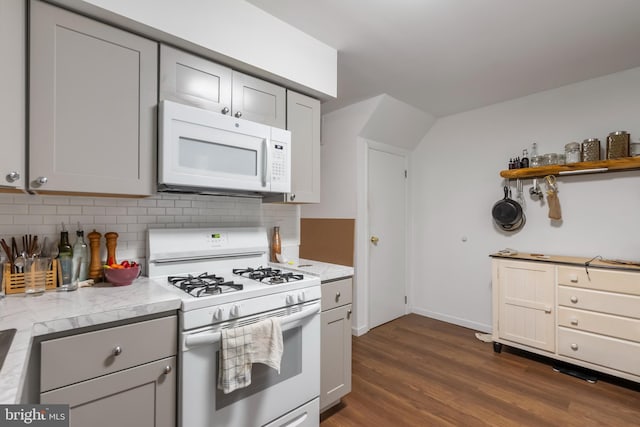 kitchen featuring gray cabinetry, decorative backsplash, white appliances, and dark wood-type flooring