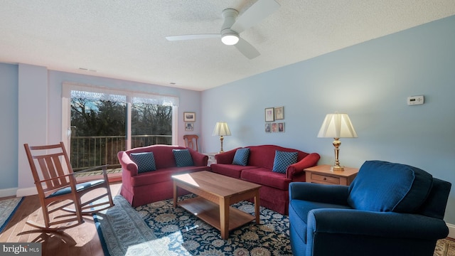 living room with hardwood / wood-style floors, ceiling fan, and a textured ceiling