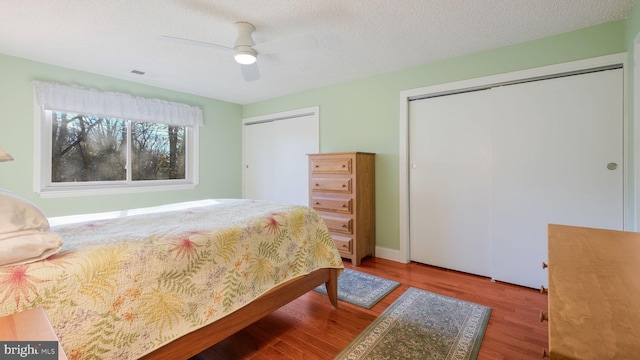 bedroom featuring ceiling fan, wood-type flooring, and a textured ceiling