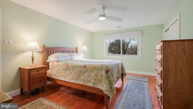 bedroom featuring a textured ceiling, hardwood / wood-style flooring, and ceiling fan