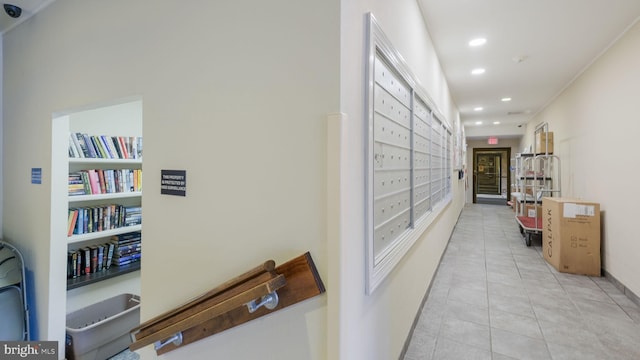 corridor featuring built in shelves, a mail area, and light tile patterned floors