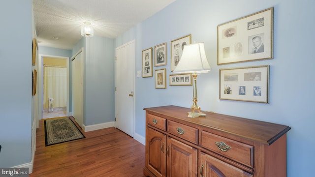 hallway featuring hardwood / wood-style floors and a textured ceiling