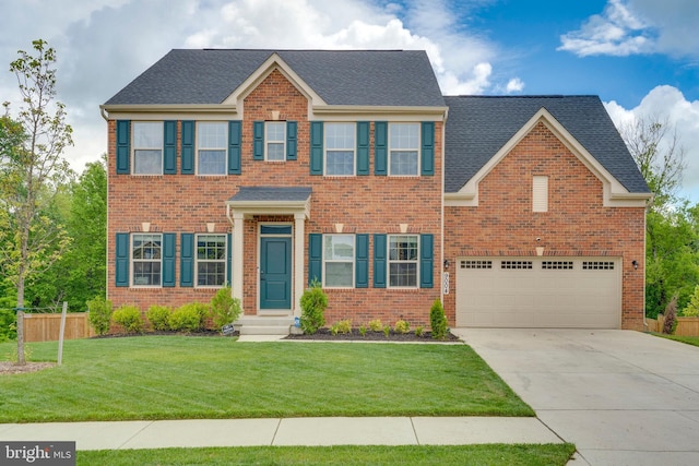 colonial home featuring a garage and a front lawn