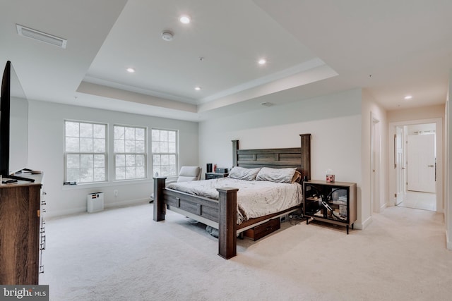 carpeted bedroom with a tray ceiling