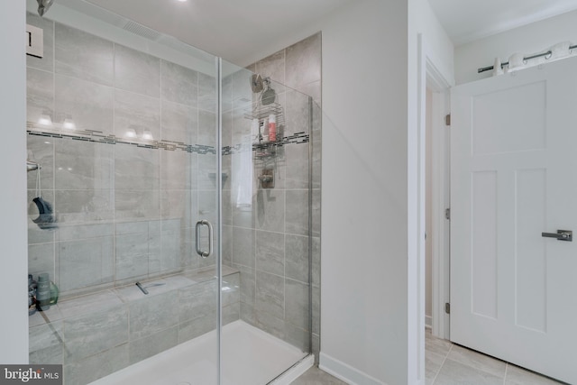 bathroom with tile patterned floors and a shower with door