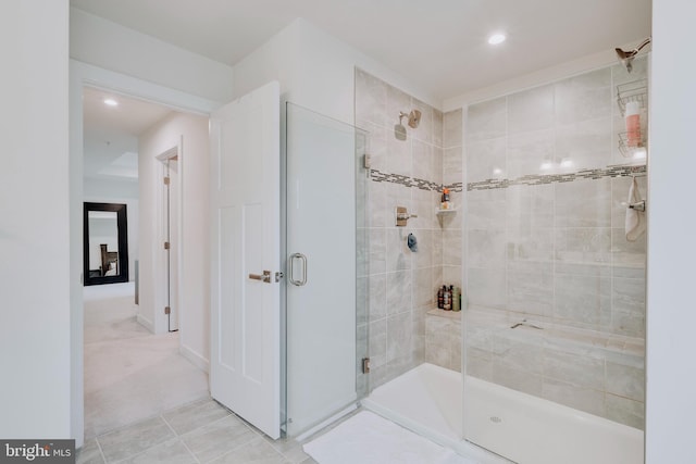 bathroom with a shower with door and tile patterned floors