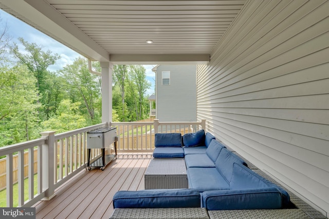 wooden terrace with an outdoor living space