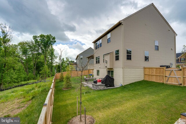 rear view of property featuring a yard and a patio area