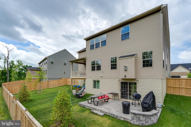 back of property with a lawn and a patio area