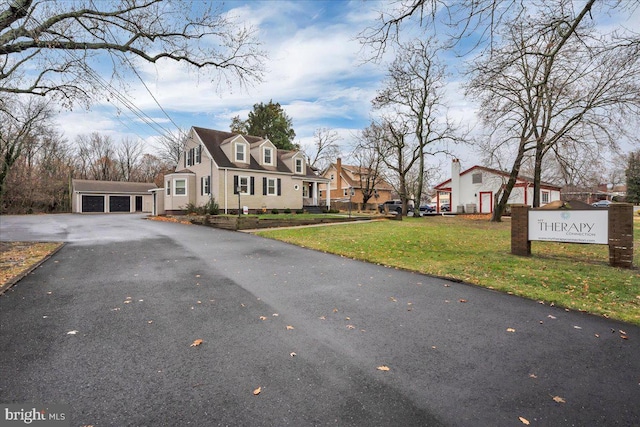 view of front of home featuring a front lawn, an outdoor structure, and a garage