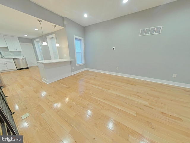 unfurnished living room with sink and light hardwood / wood-style floors