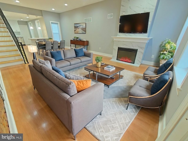 living room with light wood-type flooring and a premium fireplace