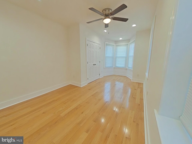 empty room with light wood-type flooring and ceiling fan