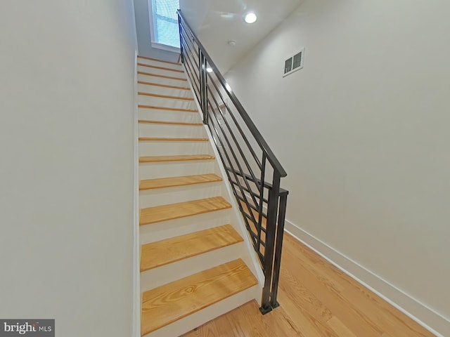 staircase with wood-type flooring