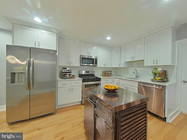 kitchen with white cabinetry, sink, light wood-type flooring, and appliances with stainless steel finishes