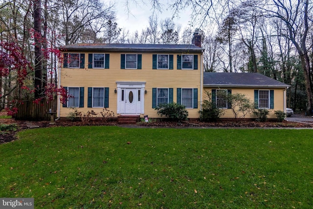 colonial house featuring a front lawn