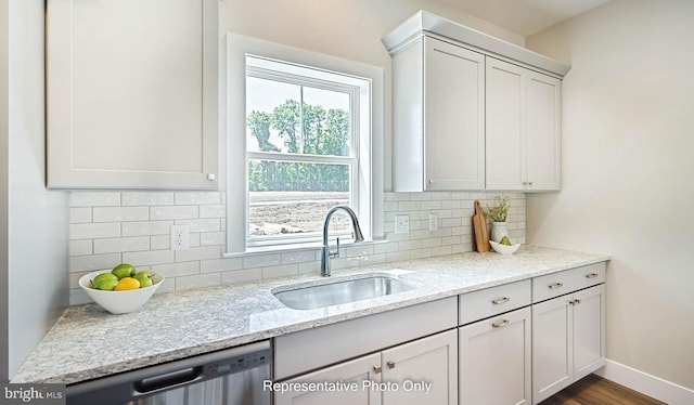 kitchen featuring light stone counters, dark wood-type flooring, sink, dishwasher, and white cabinetry