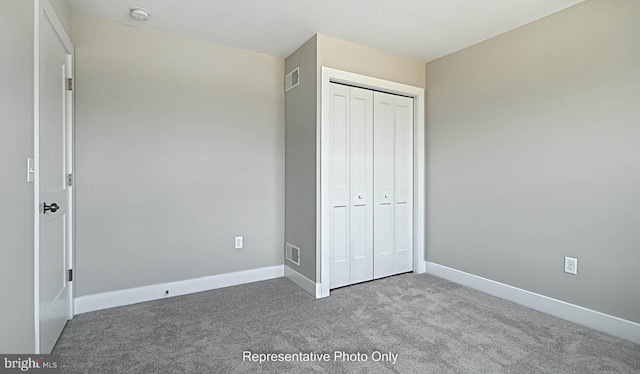 unfurnished bedroom featuring carpet flooring and a closet