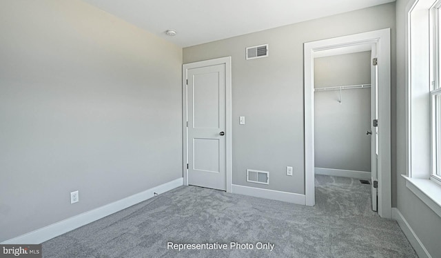 unfurnished bedroom featuring carpet and a closet