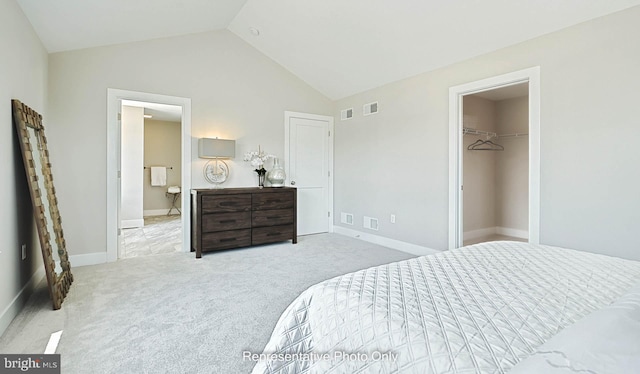 carpeted bedroom with a spacious closet, a closet, and lofted ceiling