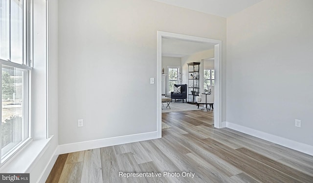 unfurnished room with light wood-type flooring and a wealth of natural light