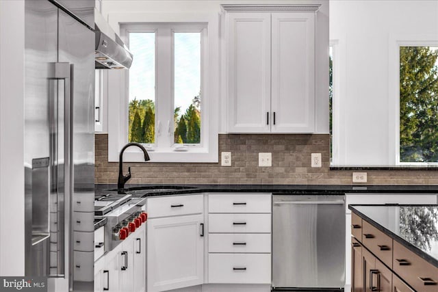 kitchen with dark stone countertops, sink, white cabinets, and appliances with stainless steel finishes