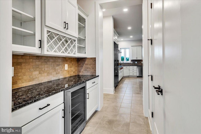 kitchen with wine cooler, dark stone countertops, and white cabinets