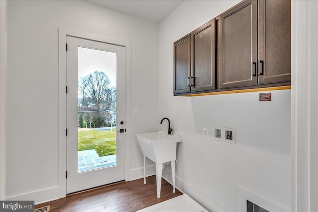 washroom featuring cabinets, dark wood-type flooring, and hookup for a washing machine