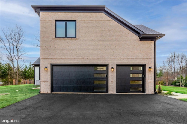 view of side of property featuring a yard and a garage