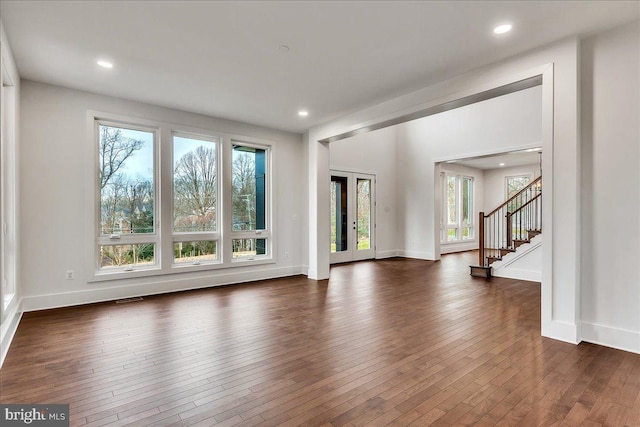 unfurnished living room with dark hardwood / wood-style flooring and french doors